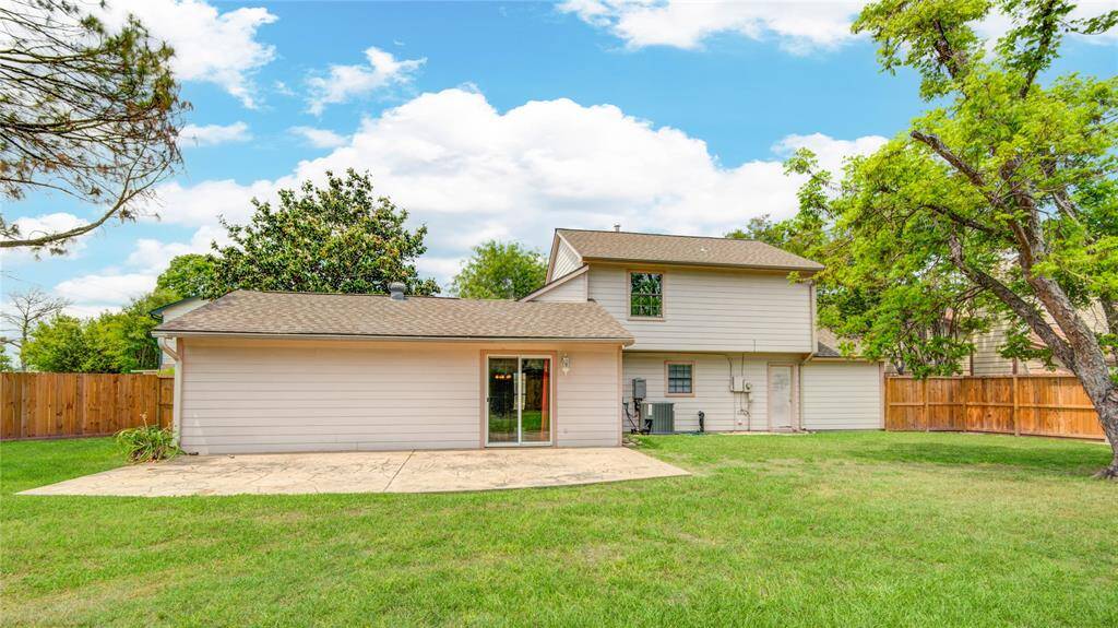 Expansive backyard view featuring a spacious patio—perfect for outdoor dining, entertaining, or relaxing under the trees.