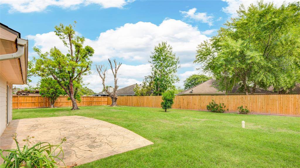 Enjoy peaceful afternoons on the spacious patio overlooking the fully fenced, tree-lined yard.