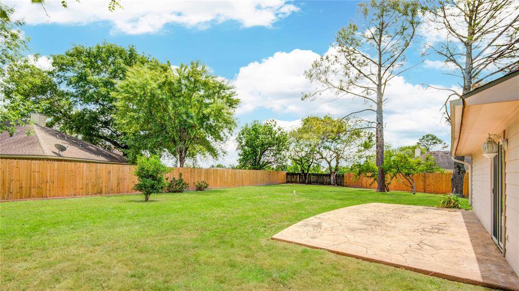 Expansive backyard with mature trees and plenty of room to entertain, play, or relax in privacy.