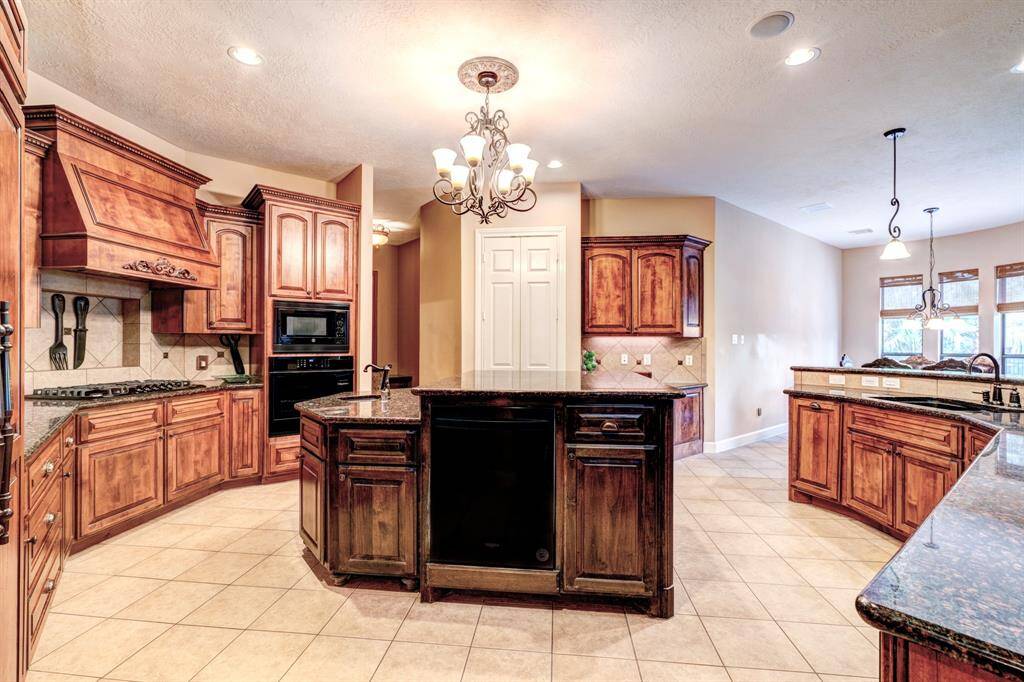 Whether cooking solo or with the family, this gourmet kitchen adjusts for many culinary situations. Custom wood cabinetry is in ample supply for kitchen gadgets and necessities, while the double ovens and three sinks allow for easy and quick cooking.
