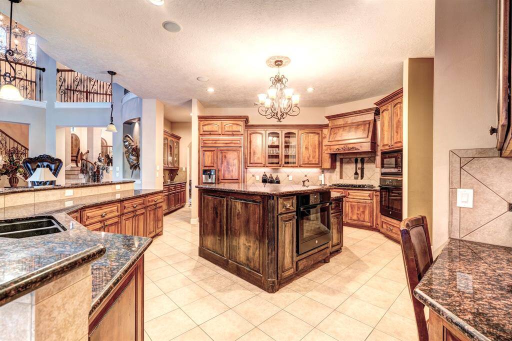 Featuring sprawling granite countertops and a built-in desk, the kitchen lends its versatility to creative projects as well as household accounting.