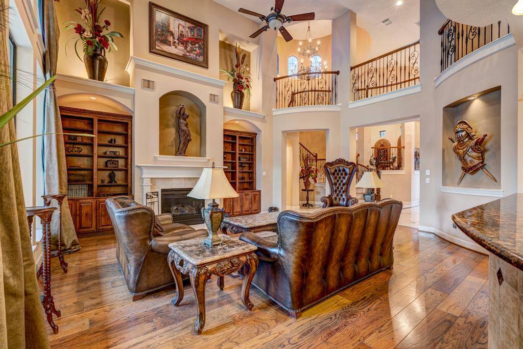 Rustic hardwood floors provide a classic appearance to the living room. Built-in bookcases add to the customized façade as they add dimension, while remaining unique and matching the kitchen cabinetry in uniformity.