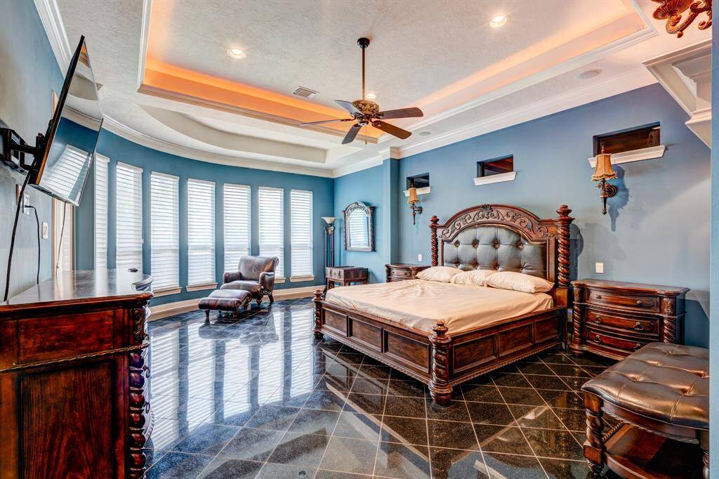 Deep tray ceilings with romantic lights welcome you every evening. Impressive in size and finishes, the glamourous main master bedroom is a sight to behold with gleaming flooring, thick crown molding, and recessed lighting.