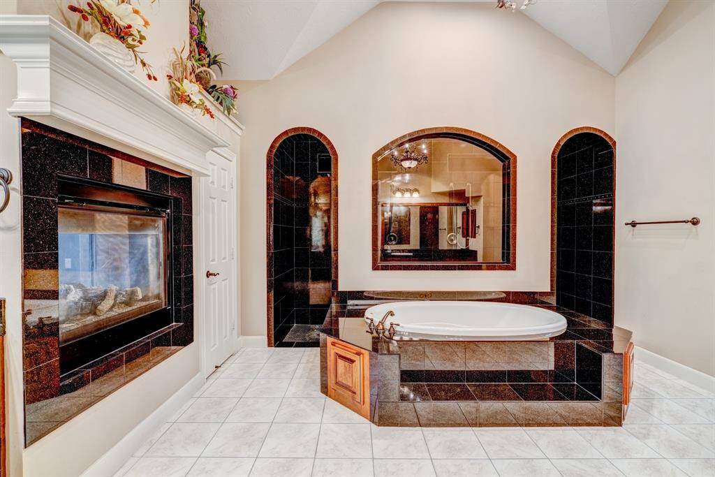 Suitable for serene ambiance, the master en suite has vaulted ceilings and a double-sided fireplace. While soaking, play soft classical music and light candles on the mantle for unparalleled bliss.