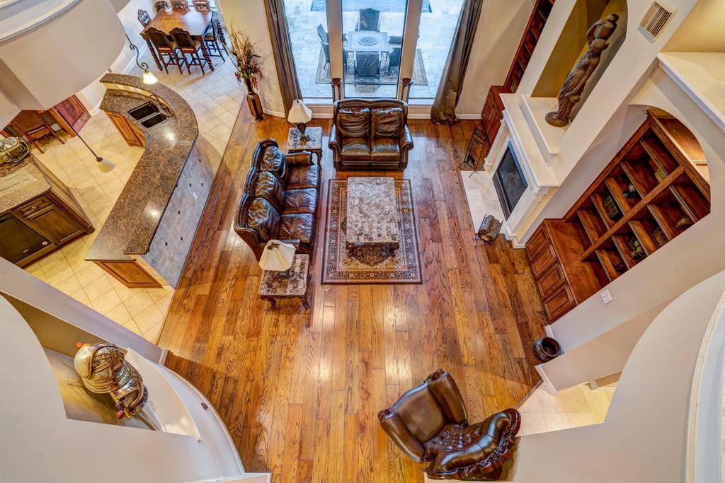 Gazing at the living room from an aerial perspective allows you and guests to appreciate the careful and deliberate design of this masterful abode. Rounded angles, inlays, recesses, and symmetrical details coalesce in a mixture of interior genius.