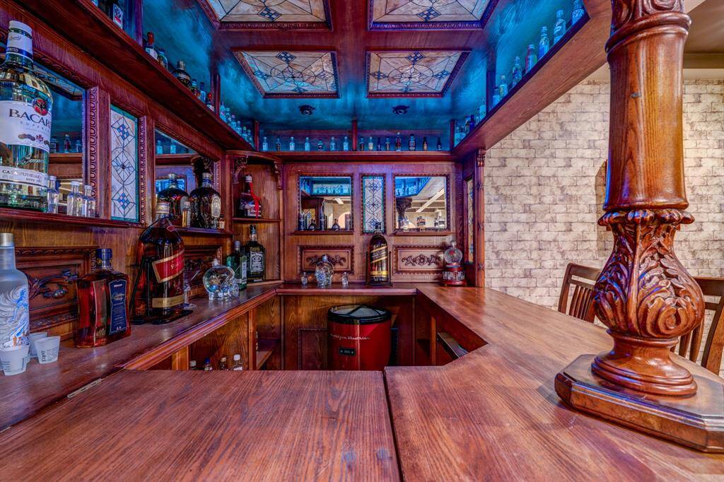 Built-in and elegantly finished, the bar is fully outfitted! Exquisite cabinetry, stained glass, and overhead lights add to the seductive authenticity of this at- home bar.