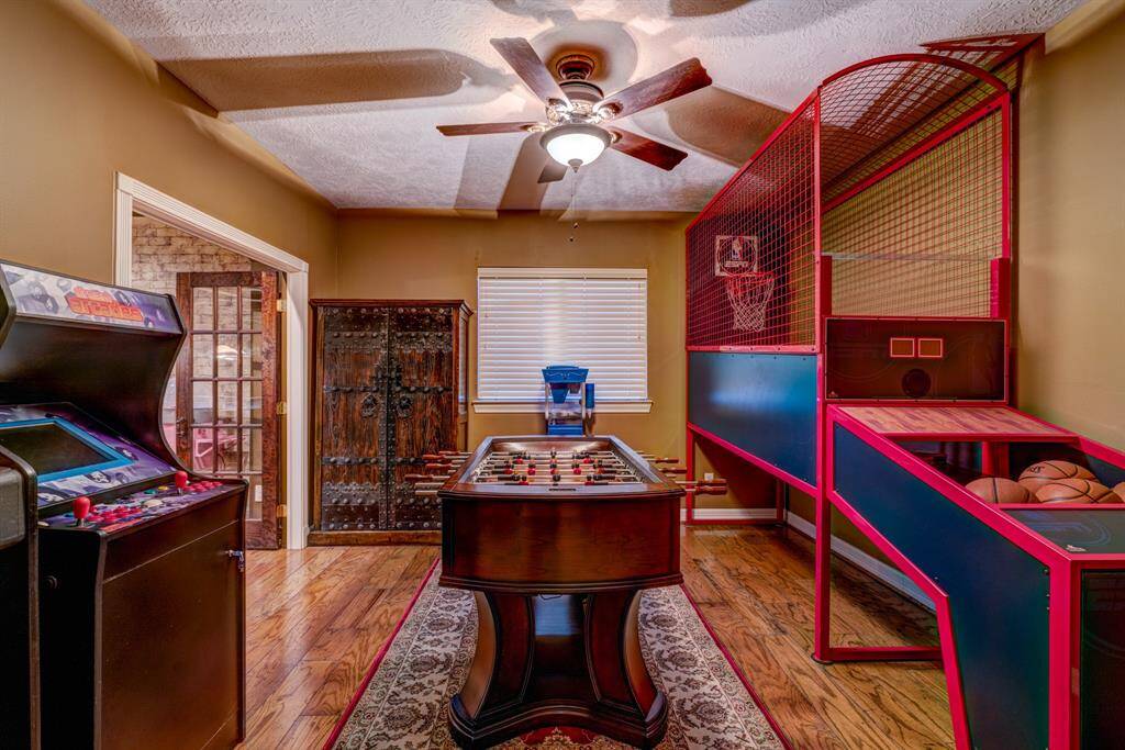 Rustic French doors create a welcoming entrance to an extra, adjacent entertainment area. Utilize the room for games or an additional distance learning space.