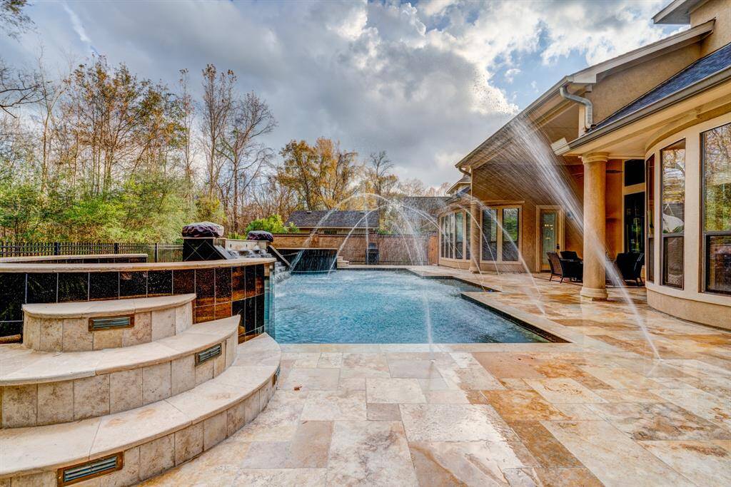 Custom stonework surrounds the gleaming swimming pool and spa. Envision catered, late evening gatherings with cocktails and decadent goodies, as you relish in fabulous company and bask in the opulence of your dream home.