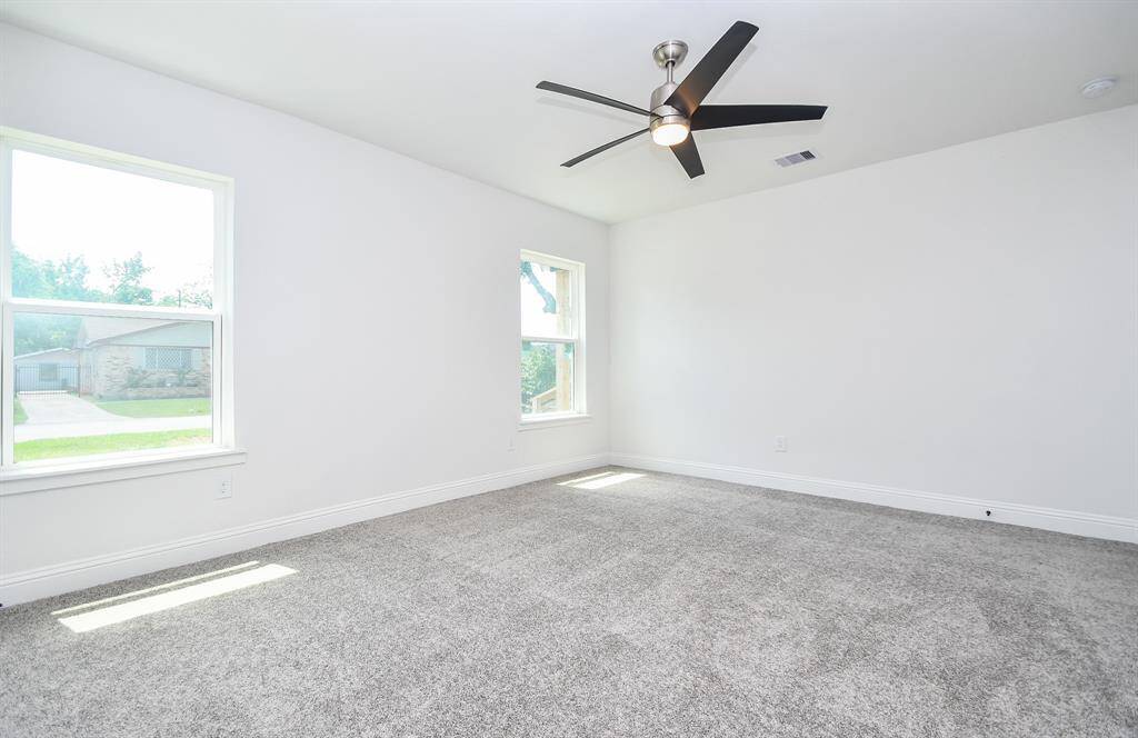 Recently installed plush carpet graces the floors of the primary bedroom. Bedroom door in on the right.