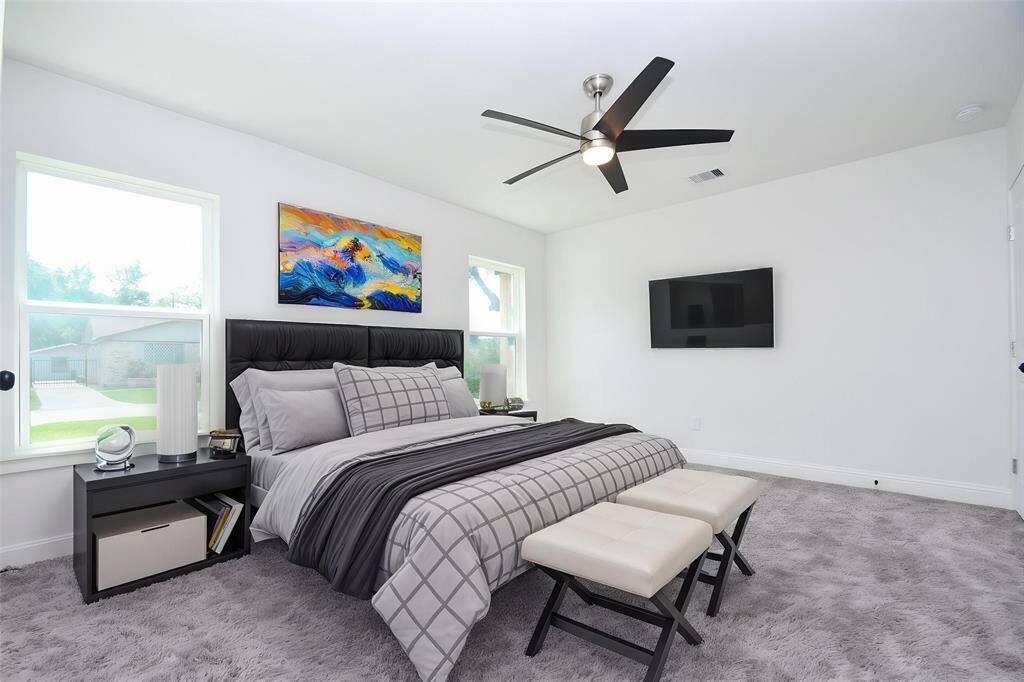 Another virtually staged version of the primary bedroom with the bed backed-up to a different wall and letting the windows flank the bed.
