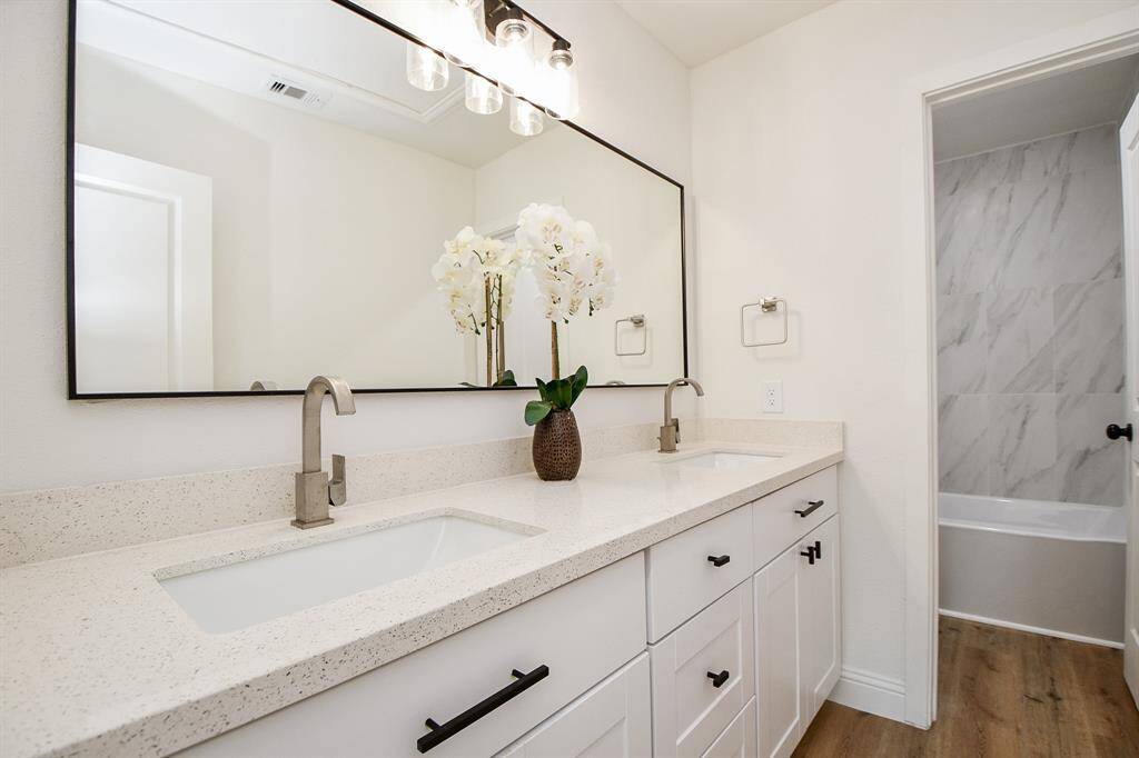 Secondary bathroom - undermount sinks, quartz counters, cabinets for storage with hardware pulls and knobs.