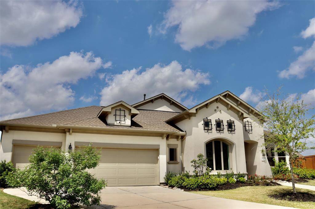 Zoomed out photo of the front exterior to show the three car garage
