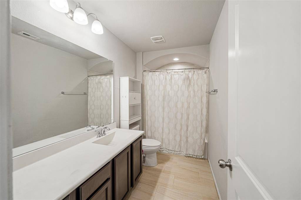 This secondary bath upstairs has sweeping countertops for space.