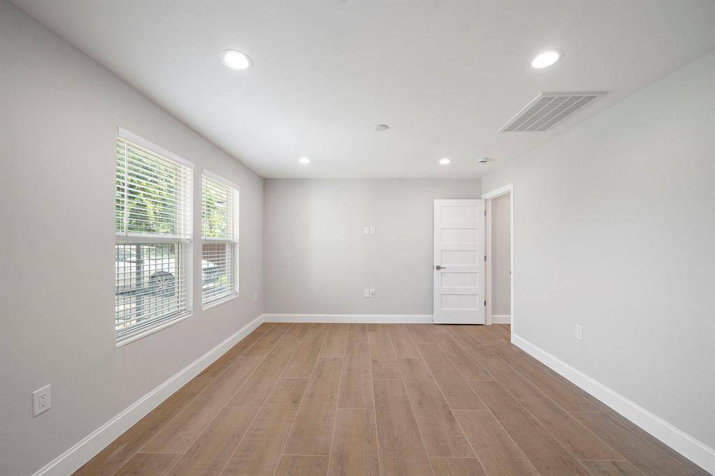 The living room with 2 large windows for natural light. The wood look tile plank flooring flows throughout the house.