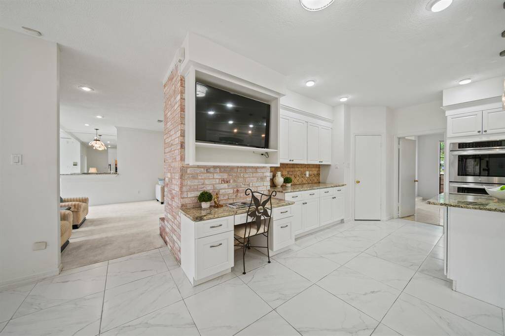 The exposed brick creates a nice back drop for the built-in desk area, located in the kitchen.