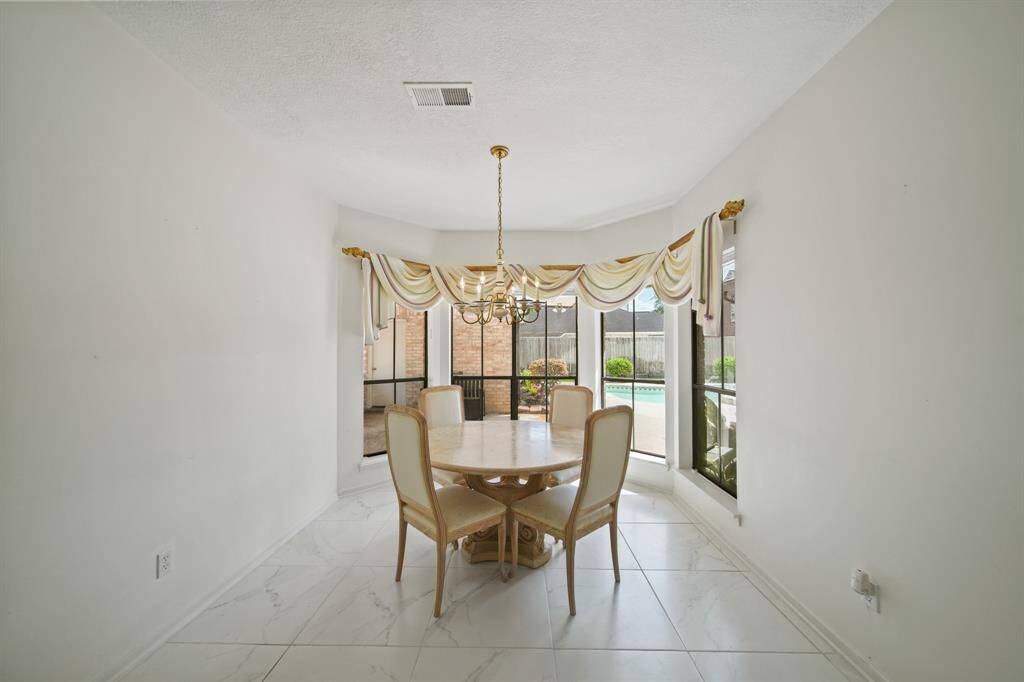 The breakfast nook is adjacent to the kitchen and has a nice wall of windows overlooking the pool.
