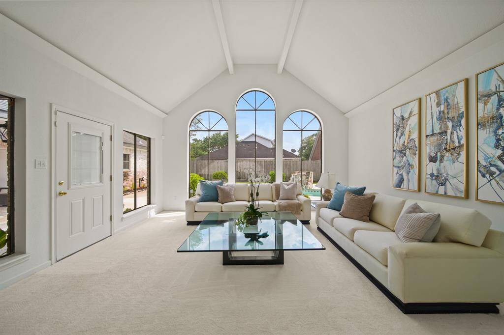 The arched windows, ceiling beams and vaulted ceiling create a dramatic formal living room.