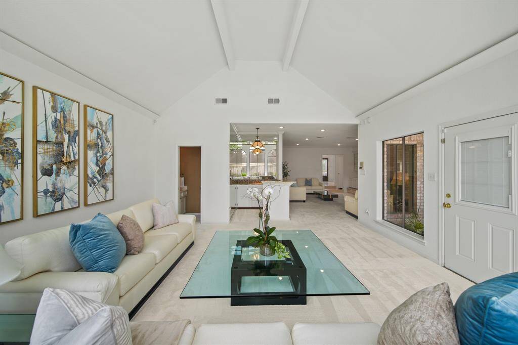 The "formal living" room has a door leading to the backyard, as well as a picture frame window overlooking a courtyard.