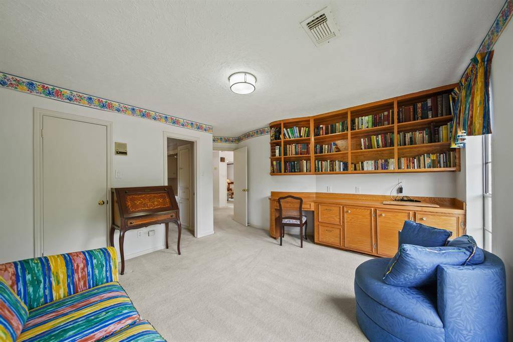 This large home office has built-ins and a built-in desk. It also has a large closet, so could be used as an additional bedroom.