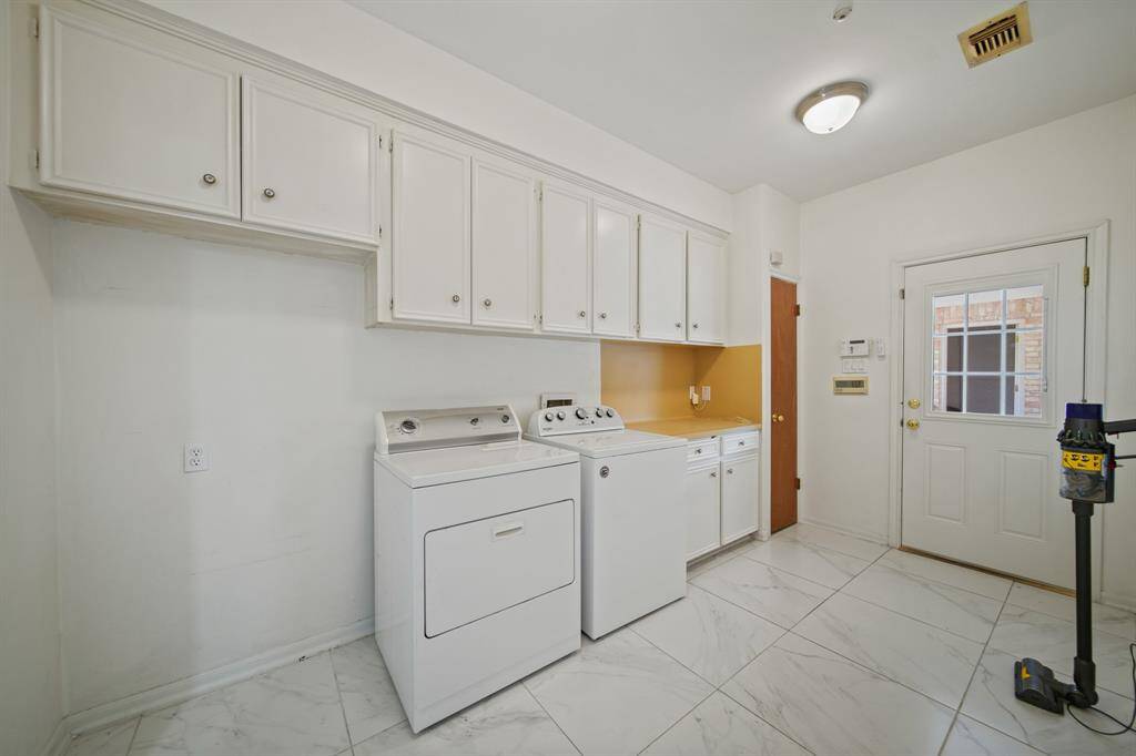 The utility room is very spacious. It has room for a refrigerator, plenty of built-ins to keep your laundry supplies organized and a broom closet.