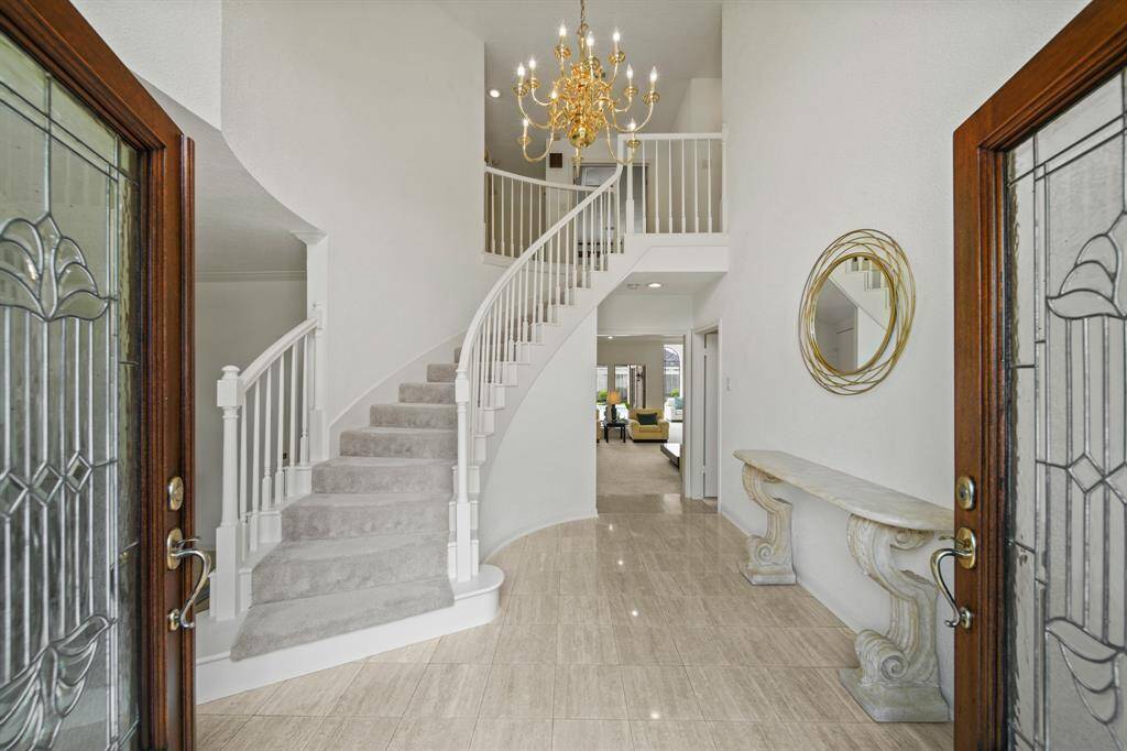 The double lead glass panel doors open to a beautiful custom home that is classic in design.