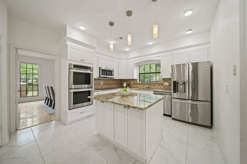 The chef's kitchen was updated in 2017. Features include oversized tile, painted cabinets and granite countertops.