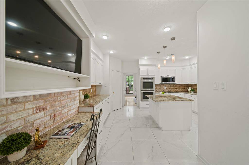 The kitchen has a built-in desk and TV niche.