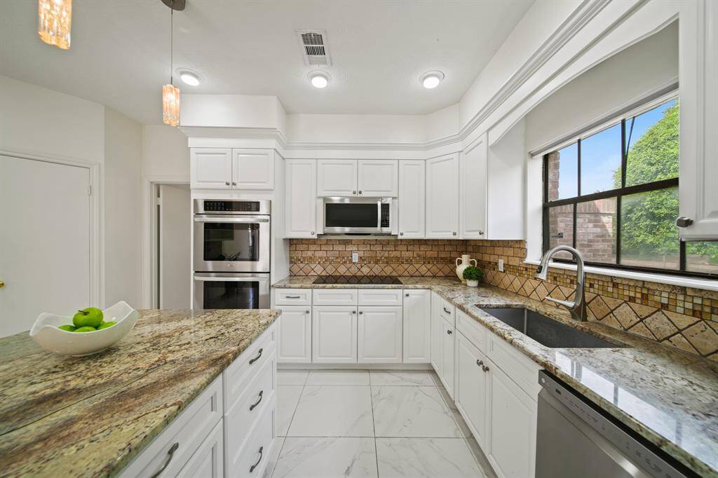 Appliances, including a stainless double oven, were replaced in 2017. The window, over the oversized undermount stainless sink, keeps the kitchen light and bright. Notice the recessed lighting, as well as the pendant lights.