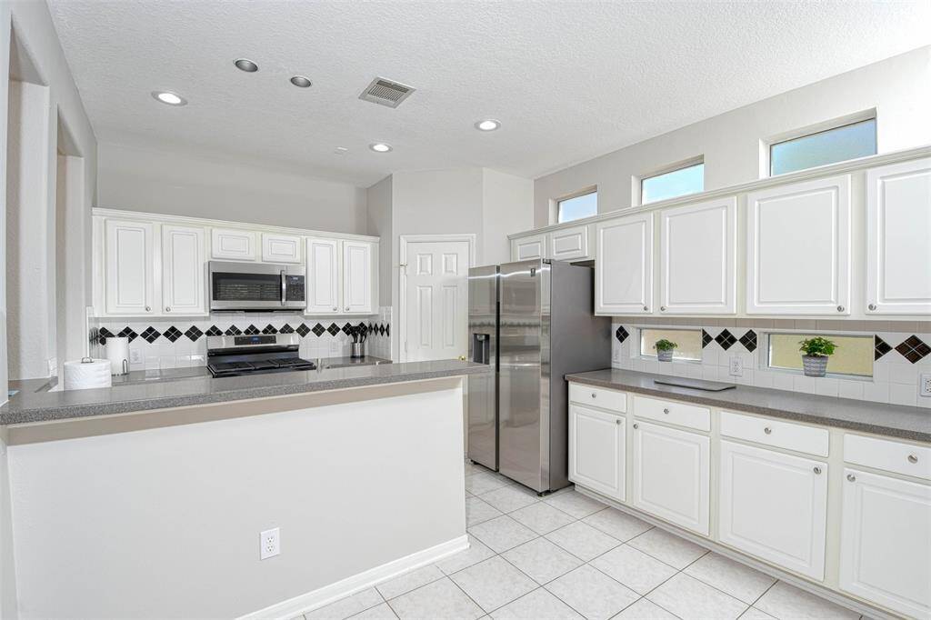 Lots of natural light in the kitchen with a spacious pantry and tons of cabinet space.