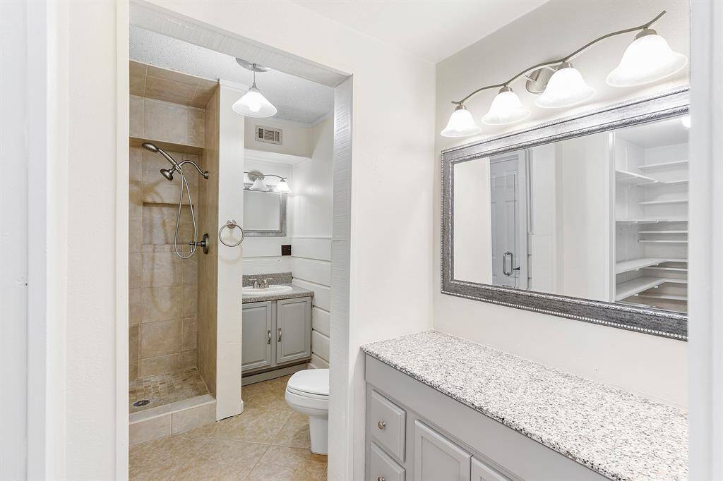 The ensuite bath is thoughtfully designed with both comfort and convenience in mind, featuring a stand-up shower with a built-in seat for a spa-like experience. A separate vanity area offers a dedicated space for your daily routine, while a walk-in linen closet keeps essentials neatly organized and close at hand.