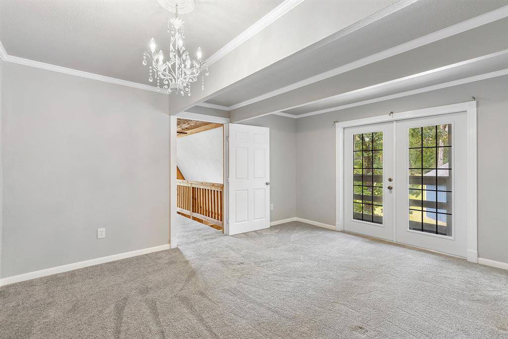 Generously sized secondary bedroom features a chandelier and French doors that open to the front balcony!