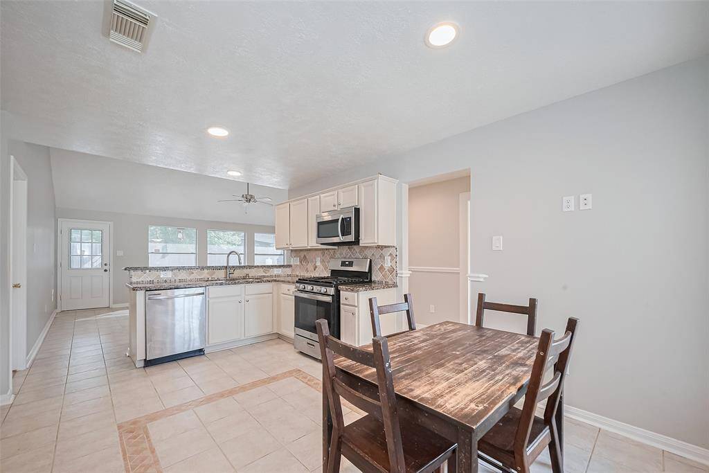 Open-concept kitchen with granite countertops, gas stove, and stainless steel appliances. Ready for your favorite meals!