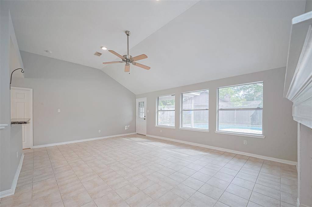 Spacious living and dining area with high ceilings and plenty of windows, filling the space with natural light and offering beautiful views of the pool.