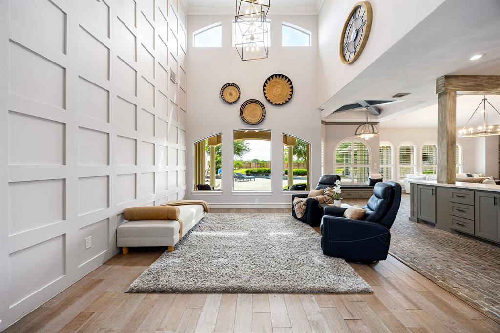 family room with large paneled wall adding to the elegance of this home