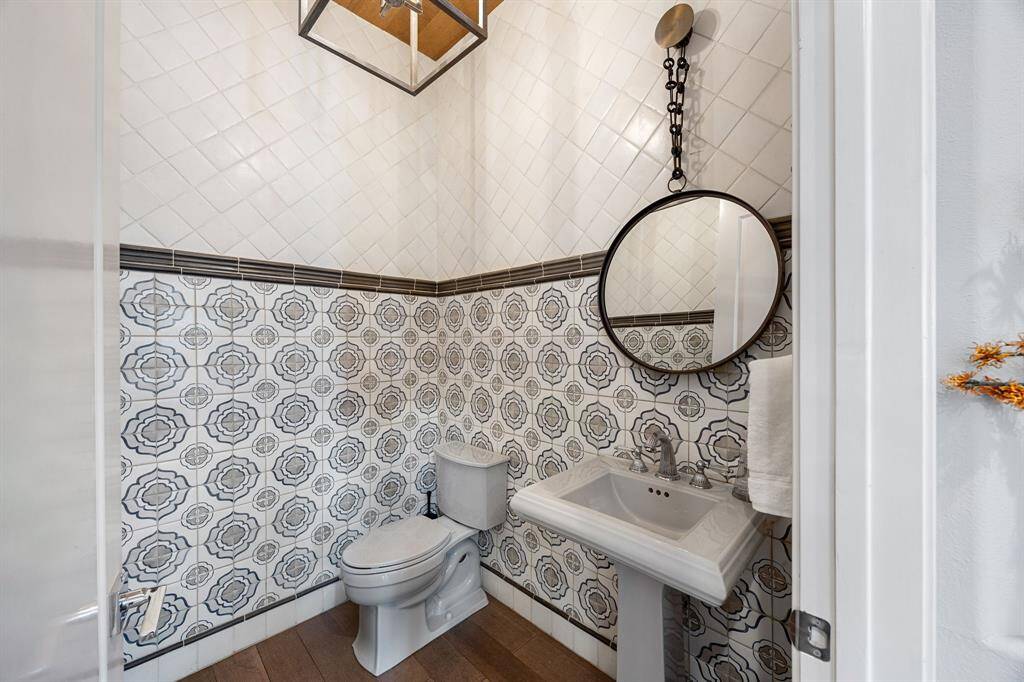 luxurious powder room on first floor with decorative mirror and pedestal style sink