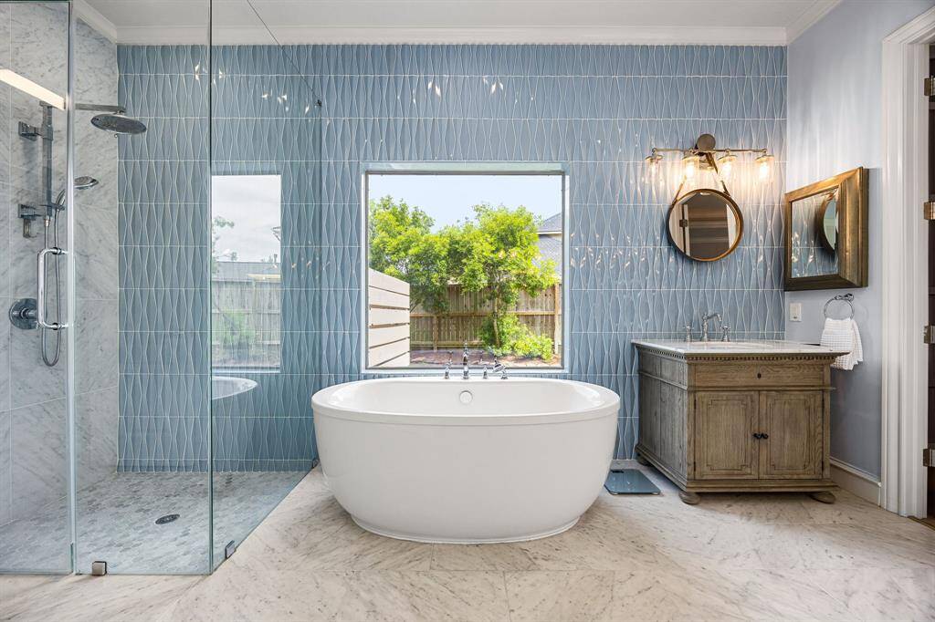 Notice the light blue mosaic luxury tile in this ensuite primary bath with soaking vintage tub