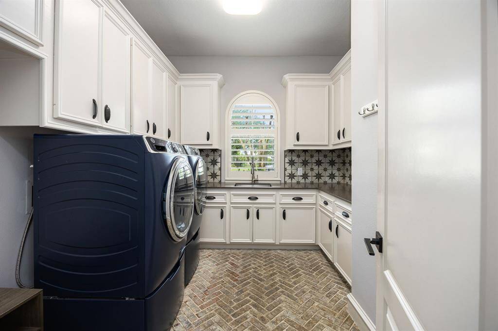 Utility room with cabinet space, durable brick floors and sink