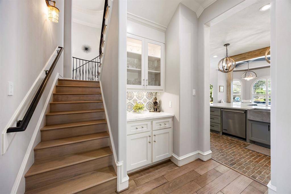 View of the dry bar on hallway leading to kitchen and secondary staircase