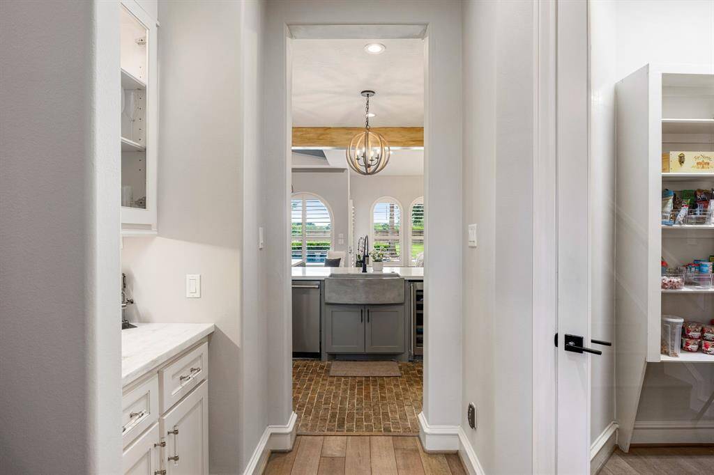 view of kitchen, dry bar and pantry from hallway