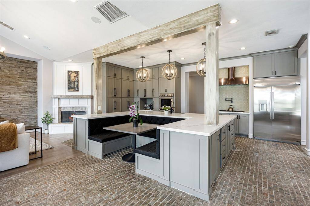 Another angle of the kitchen with luxurious wooden beams across the quartz countertops