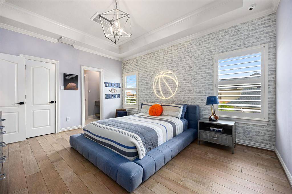 bedroom with brick accent wall and built-in shelves