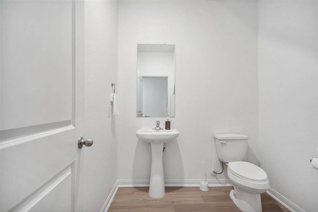 Half bath downstairs to left of the staircase with its own hallway.