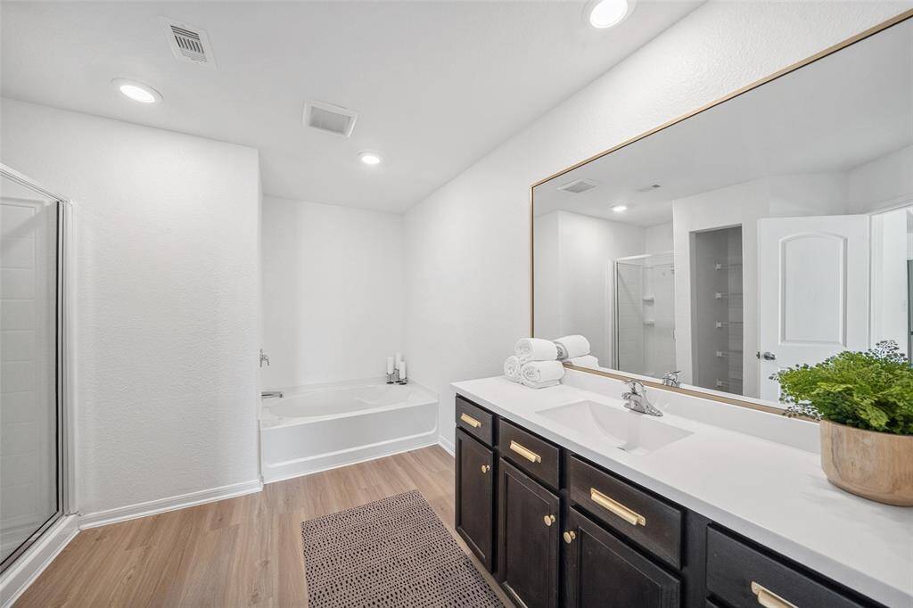 Large primary bathroom with soaking tub and shower. Also storage closet not visible to left.