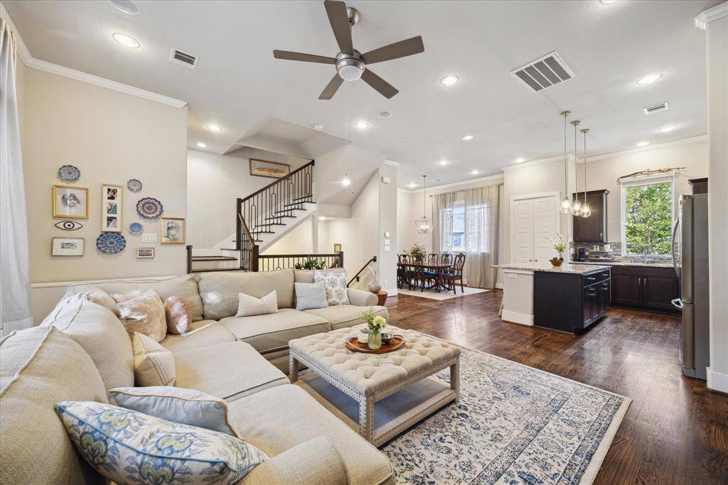 The living room features a spacious, open layout that seamlessly flows into the kitchen and dining areas.