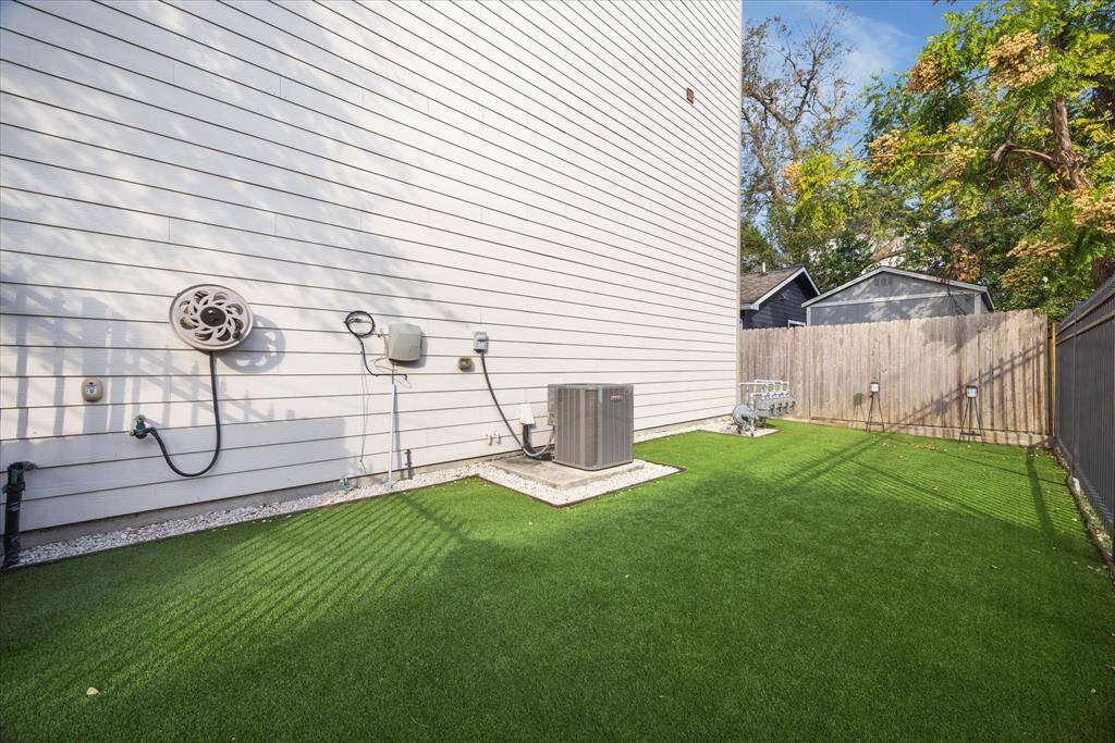 Spacious backyard has an artificial turf for easy maintenance.