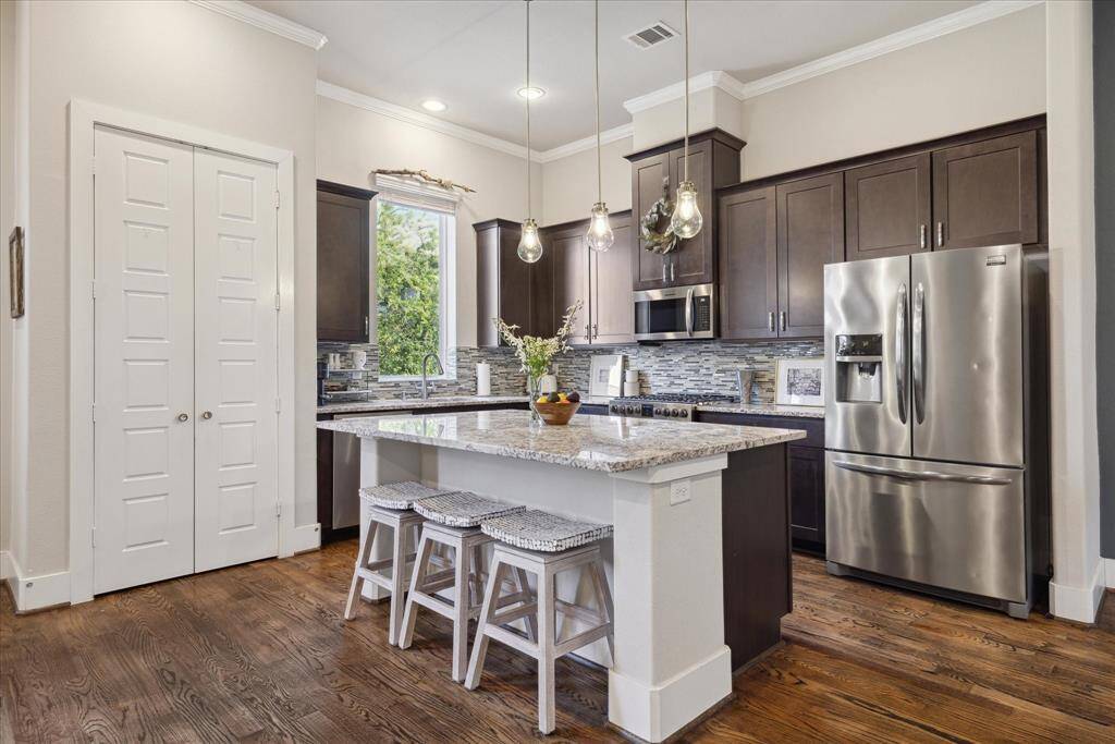 The kitchen boasts an island with seating bar, accented by stylish pendant lights, and has a pantry.
