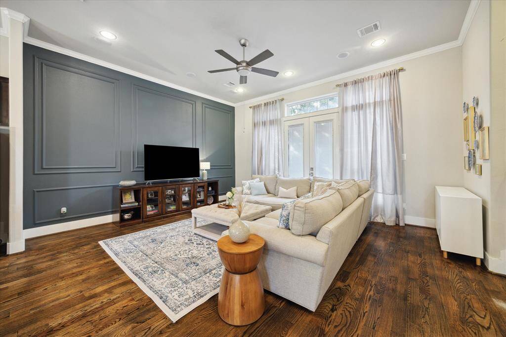 Another view of the living room with accent wall and a French door to the balcony.