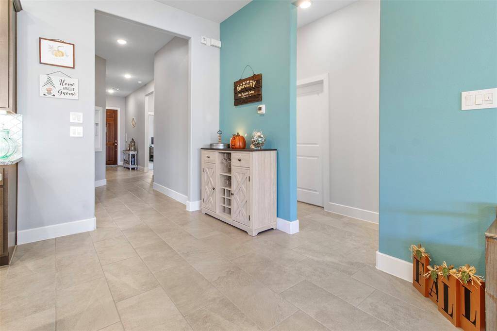 Living room features tile flooring, aceiling fan, custom paint, and large windows.