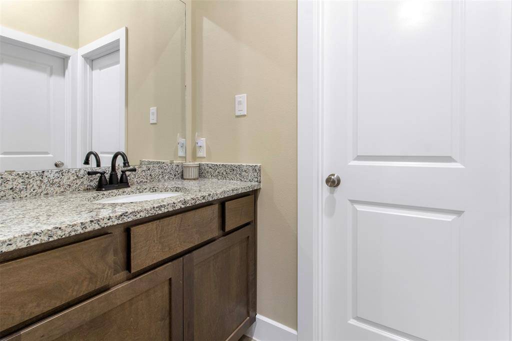 The primary bathroom features wood cabinets and a walk-in shower with tile surround and glass door.