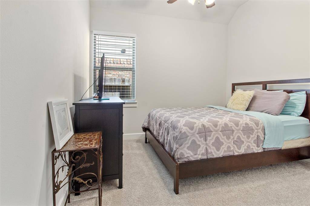 Secondary bedroom features awindow and plush carpet.